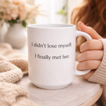 hite ceramic coffee mug with the quote “I didn’t lose myself, I finally met her” on a neutral background