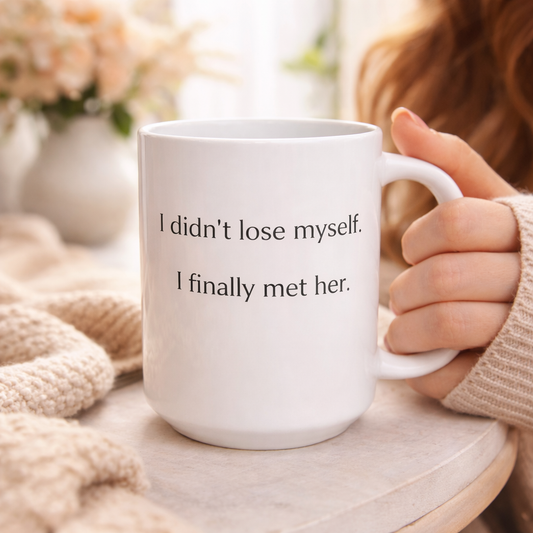hite ceramic coffee mug with the quote “I didn’t lose myself, I finally met her” on a neutral background