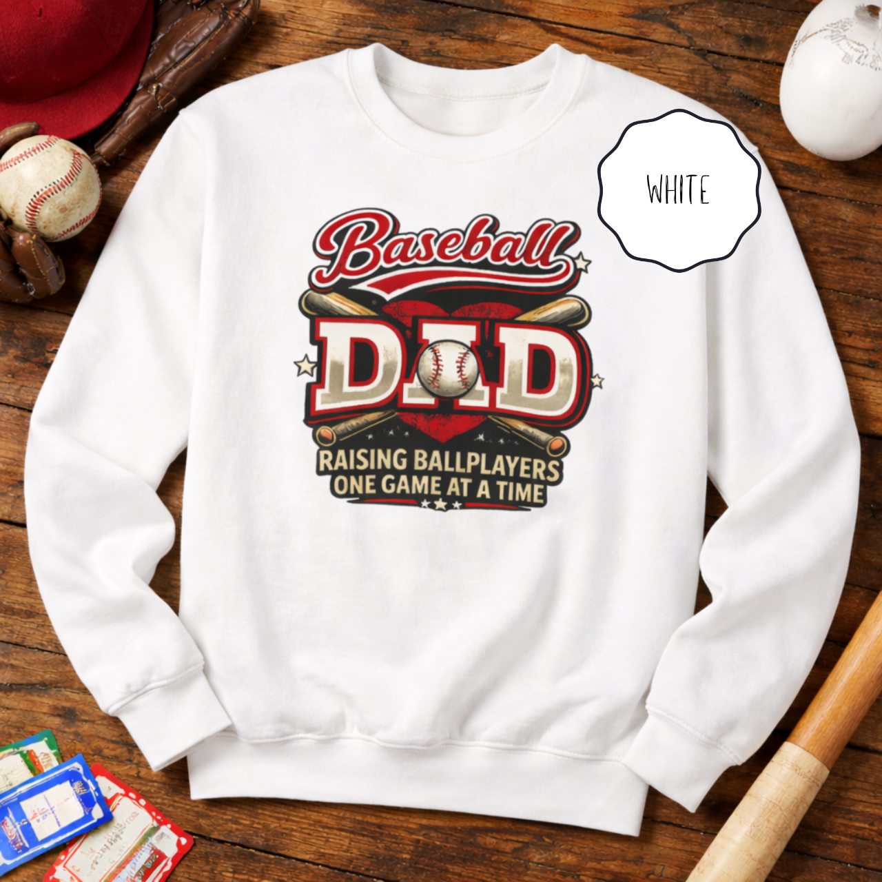 Black baseball dad sweatshirt with “Raising Ballplayers One Game at a Time” graphic displayed on a wooden background