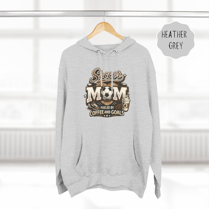 Neutral color soccer mom hoodie hanging on hanger with coffee and goals design